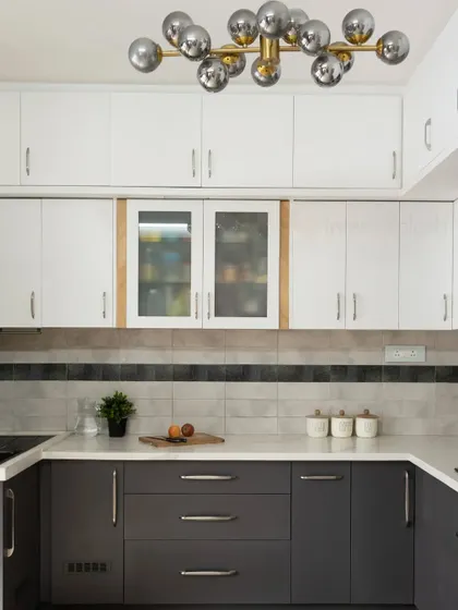 A two-tone kitchen design with dark grey and white cabinets. The modern bubble chandelier adds a sculptural and playful element to the space.