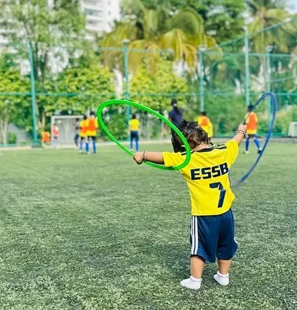 A young player enjoys a fun agility game with a hula hoop during our kids' football training session.