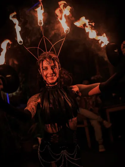 A smile from behind the flames. Beyond the performance, we are artists and craftspeople. We design and build custom fire props like this crown and offer lessons for those who want to start their own journey with fire.