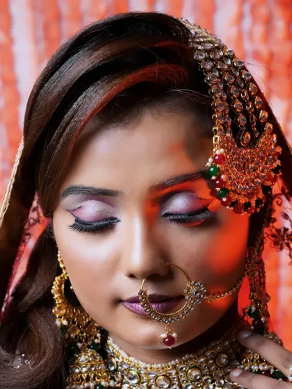 A detailed close-up of the eye makeup for the Heeramandi-inspired look. A sharp, winged liner with soft, shimmery eyeshadow creates a captivating gaze. The intricate nath and passa add to the traditional yet glamorous feel.
