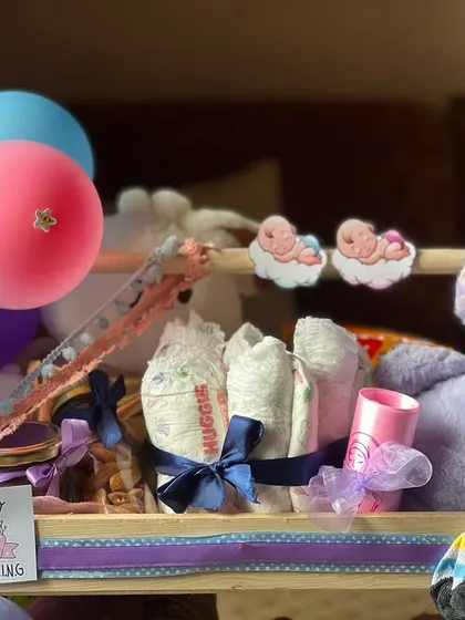 This angle highlights the cute baby cutouts and the "A Baby is Coming" sign. I pay close attention to these details to create a cohesive and heartwarming gift.