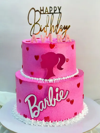 A two-tier Barbie theme cake in her signature bright pink. This is a fondant-free design, using stencils and buttercream for a clean, modern look.