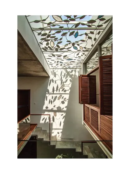 The view from the upper floor of the Cube Square residence, where a custom skylight with a leaf motif casts beautiful, organic shadows on the wall. This detail showcases our love for creating poetic and artistic moments through architecture.