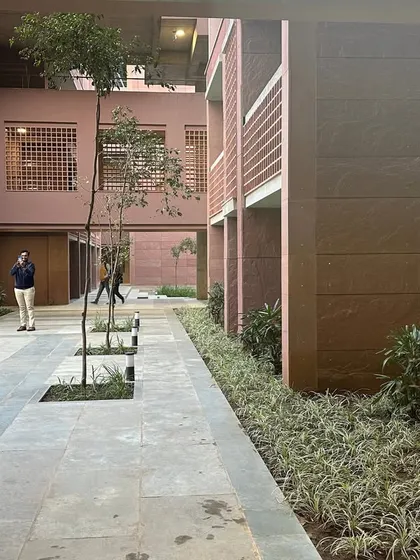 A walkway through a courtyard at Azim Premji University. The building is clad in local Farsi sandstone, which provides insulation and connects the design to its regional context.