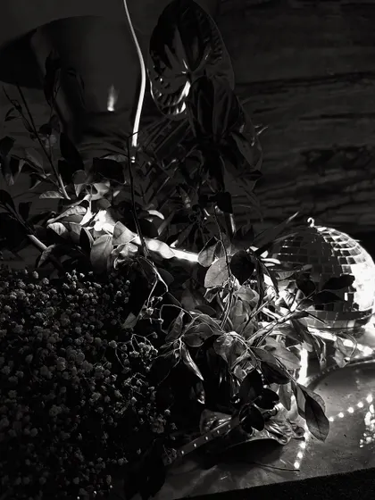 A black and white, artistic shot of some of the party decor elements, including a disco ball and florals. This highlights the interesting textures and shapes in our designs.