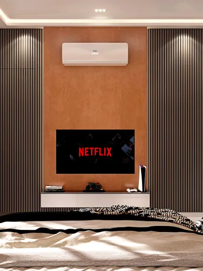 This bedroom design focuses on a sophisticated entertainment experience. The television is mounted on a textured tan accent wall, framed by dark, vertically fluted panels that conceal wardrobe space, creating a clean and integrated look.