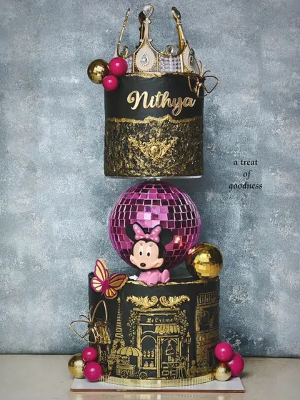 A show-stopping floating cake designed for a Minnie Mouse disco theme. This unique structure features a sparkling disco ball separating two tiers of black and gold cake, detailed with a crown and intricate stenciling.
