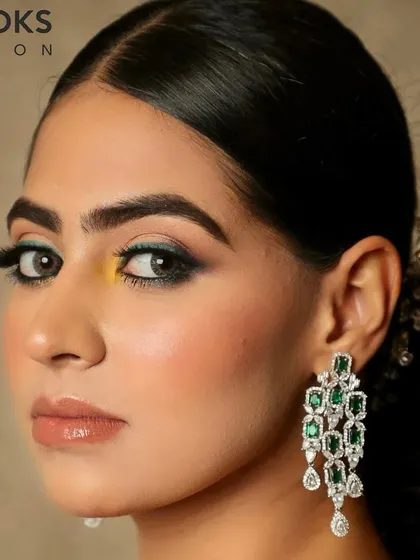 A pop of color makes this party look unique. We used a touch of yellow and teal on the eyes to complement the emerald jewelry, creating a modern and artistic makeup style for a special occasion.