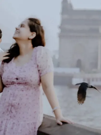 A candid and happy moment captured near the Gateway of India, with a bird in flight adding a dynamic element.