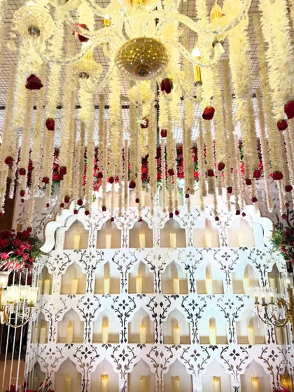 An entrance to remember. Golden glimmers and showers of white and red florals create a magical pathway, setting a tone of opulence from the very first step.