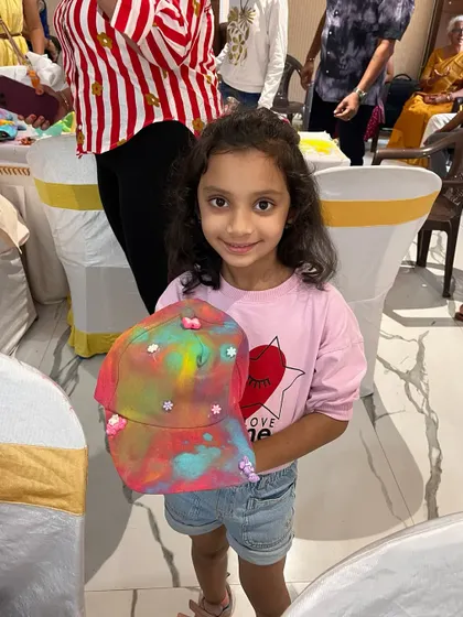 This little girl is so happy with the colorful tie-dye style cap she created at a birthday party. Wearable art is always a hit with the kids.