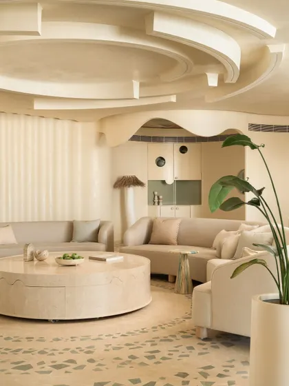 The living room of our Soft Serve project is an exercise in curves and circles. The space is unified by an ecru color palette and a large, custom rug with radiating patterns.