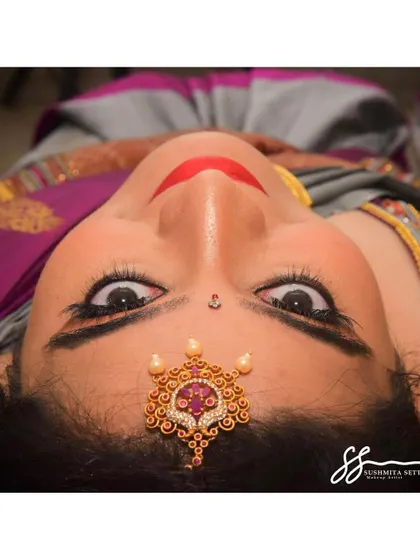 This artistic angle highlights the beautiful symmetry of the makeup and the intricate details of the bride's jewellery, showing how every element comes together.