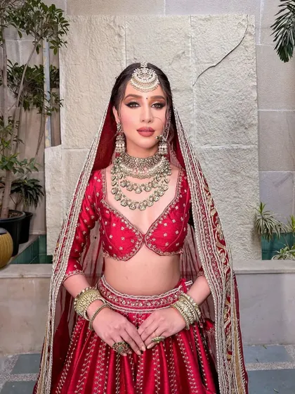 A full-length portrait of the Aafreen bride, with her veil perfectly framing her face.