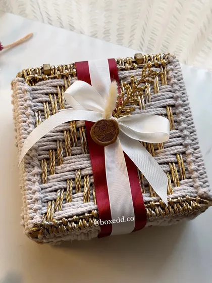 Another angle of our unique woven invitation box. The combination of red and white ribbons with a custom wax seal adds a touch of classic elegance to the rustic, handcrafted box.