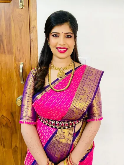 A forever favorite look for a treasured client. This vibrant pink and violet Kanchipuram silk saree is paired with a custom-designed blouse, creating a timeless and elegant ensemble for her special occasion.