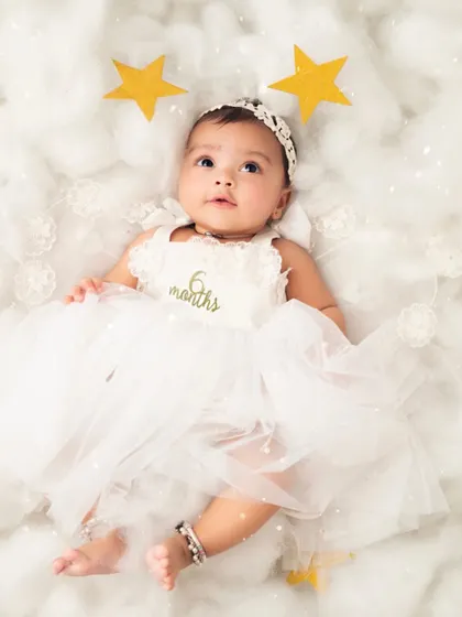 Celebrating six months with a heavenly theme. The '6 months' detail on her dress makes this a perfect milestone portrait.