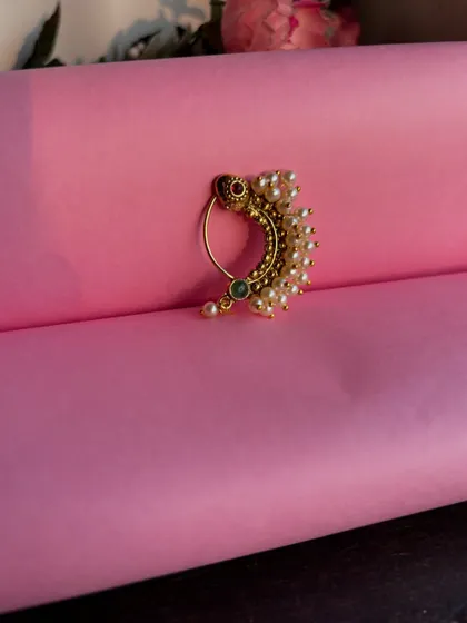 A still image of the pearl nath against a pink background.
