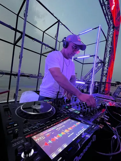 A close-up of me in the zone, mixing tracks at the beachside event. Every destination gig gets my full attention to detail to ensure a flawless musical journey.