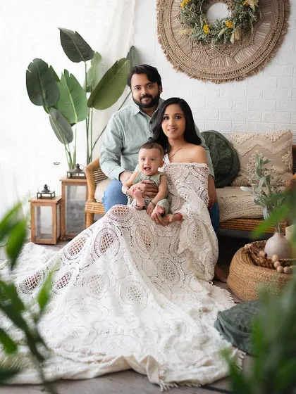 A beautiful family portrait with a natural, earthy feel, thanks to the boho decor and green plants.