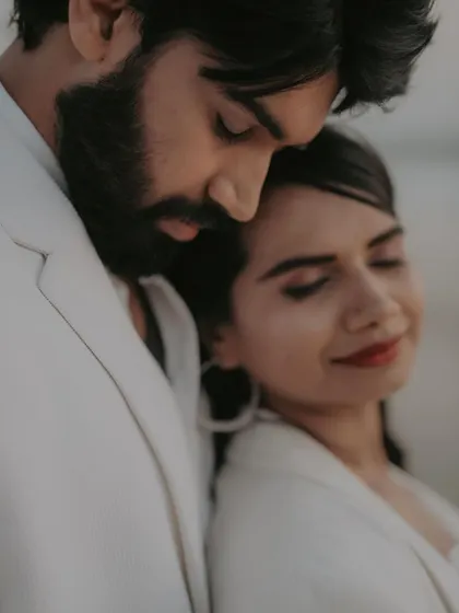 An intimate, soft-focus close-up. This dreamy shot focuses on the tender connection between the couple, with the gentle beach light adding to the romantic mood.