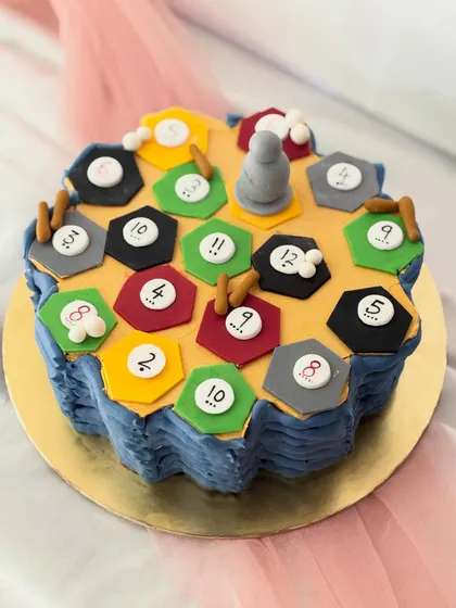 For the board game fanatic, a cake replica of the Settlers of Catan game board. Each hexagonal tile and game piece is carefully crafted from fondant.