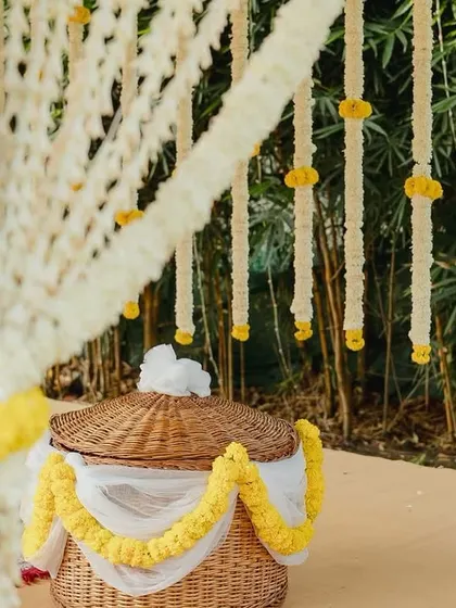 An eco-friendly and traditional detail: a woven basket decorated with jasmine and marigold flowers, used as part of our sustainable Coorgi wedding decor.