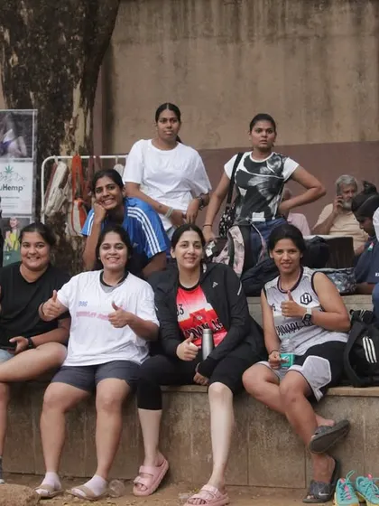 The women's team relaxing on the sidelines, giving thumbs up and peace signs. The vibe is always positive.