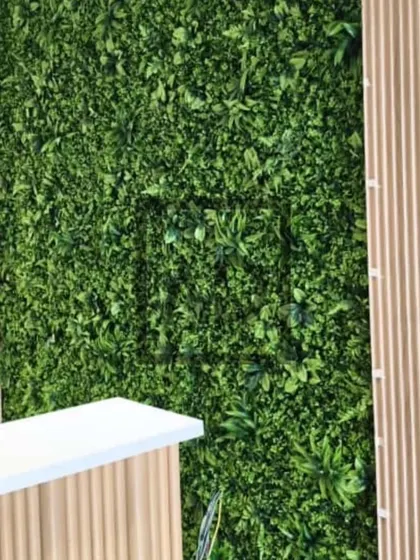 Vertical gardens are perfect for commercial interiors. Here, I installed a dense green wall next to a reception desk with light wood louver panels, adding a touch of nature to the space.