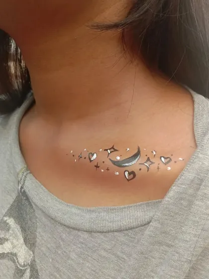 A celestial design on the collarbone, featuring a crescent moon, stars, and hearts. This is a whimsical and popular choice.
