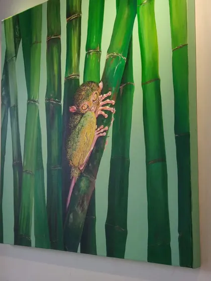 This painting by artist Isha Valentine features a tarsier, one of the world's smallest primates. The artwork, titled 'EYE-SPY', brings attention to the fragile existence of this endangered species.