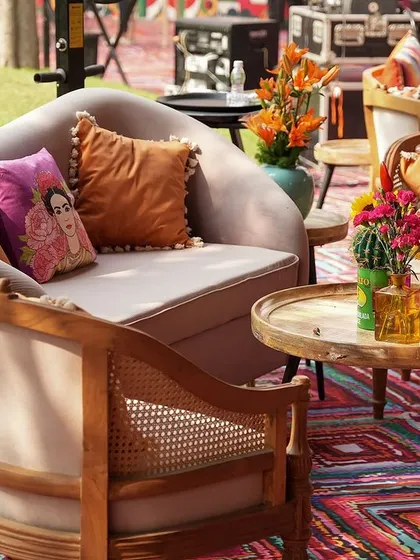 A cozy lounge area with a mix of modern and rustic furniture, set upon a vibrant, patterned rug.