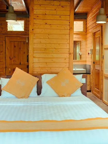 Our cozy wooden cabins feature warm lighting and comfortable bedding, creating the perfect private escape.