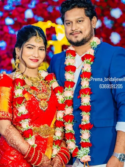 A classic portrait of the bride and groom. The bride's traditional red saree and temple jewellery create a timeless look for their wedding day.