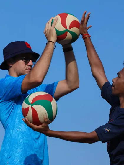I demonstrate the correct hand position for setting, working one-on-one with a player. Precision is key.