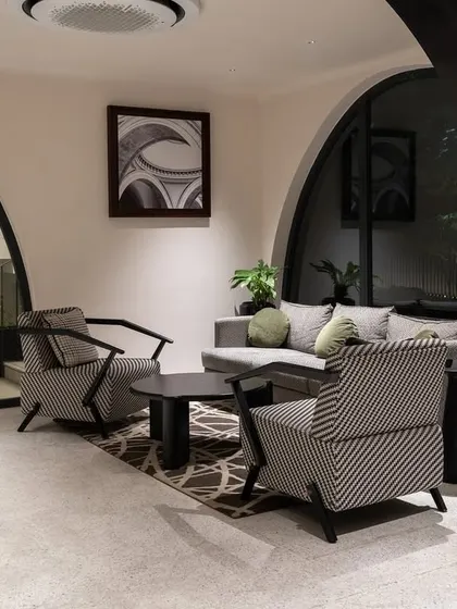 The lobby of the ARCUS residential building in Chennai. The design uses modern furniture and patterned armchairs to complement the building's signature arches, creating a welcoming and stylish entrance for residents.
