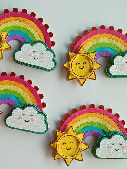 A batch of handmade sunshine and rainbow cupcake toppers. These little pieces of happiness are crafted from layered paper to bring color and joy to any dessert table.