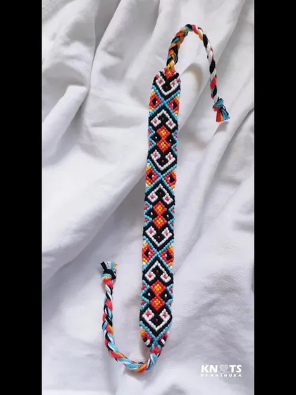 A full view of the geometric friendship bracelet, showing the beautiful, repeating pattern and braided ties.