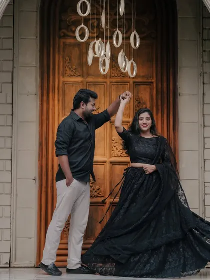 A couple shares a dance in front of a grand doorway, with modern ring lights adding a unique, glowing effect.