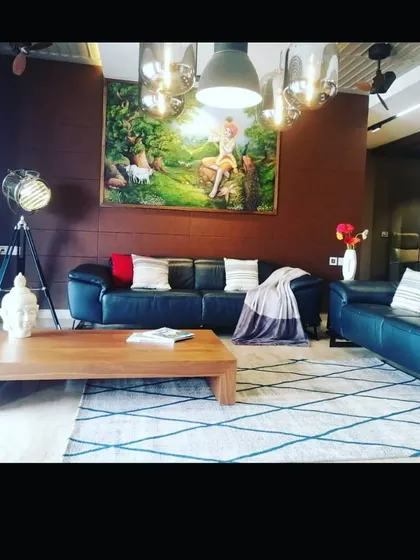 An eclectic living room where a bold, classical-style painting serves as the centerpiece. We believe in creating spaces that reflect the owner's personality, blending different patterns, textures, and art to tell a unique story.