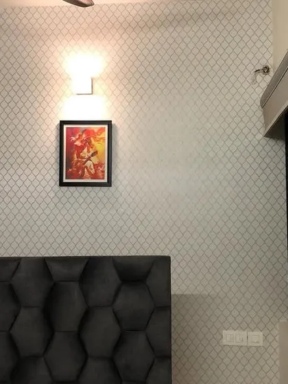 A wider view of the trellis pattern wallpaper in the bedroom.