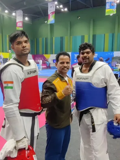 In the corner with two of our state's powerful heavyweight competitors at the National Games. Coaching at this level requires intense focus and strategy.