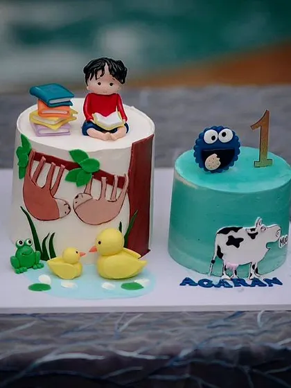 A book-themed cake for Agaran's first birthday. It features all his favorite characters, including Cookie Monster, ducks, and sloths from 'If Animals Kissed Goodnight'.