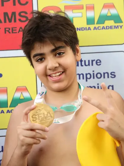 A young swimmer proudly shows off his Gold medal from the Future Champions Swimming Competition. This is where big dreams begin.