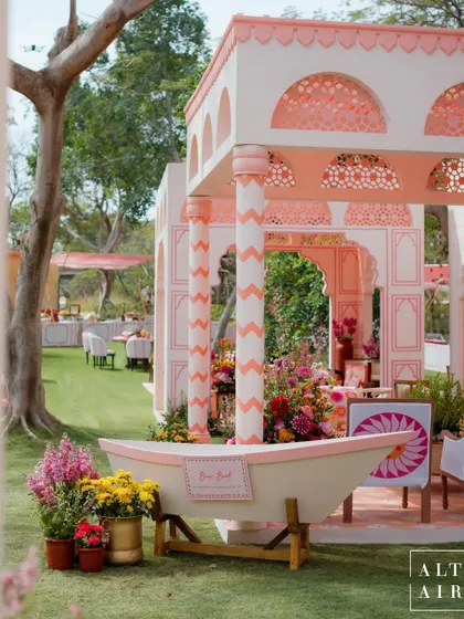 The 'Gulbahar' Holi ceremony, a modern Indian courtyard setting in quintessential Rajasthan style. A boat filled with flowers adds a whimsical touch to the vibrant and playful atmosphere.