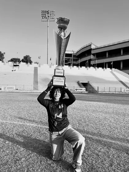 Our captain holds the championship trophy aloft, a powerful symbol of leadership and achievement. This black and white shot captures a moment of immense pride.