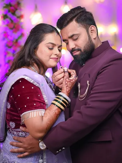 A tender moment during the ring ceremony. The couple is close together, their hands intertwined, showcasing the newly exchanged ring in a romantic embrace.