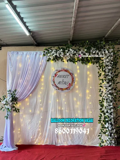 Even a simple setup can be stunning. This minimalist design uses an asymmetrical floral garland and a personalized nameplate to create a sophisticated photo corner.