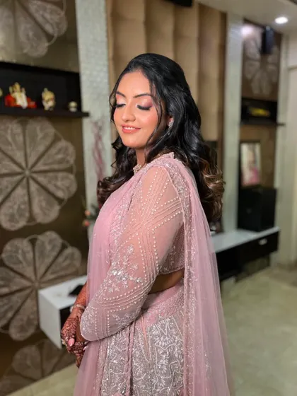A side view showcasing the soft curls in her hair and the delicate shimmer on her eyes.