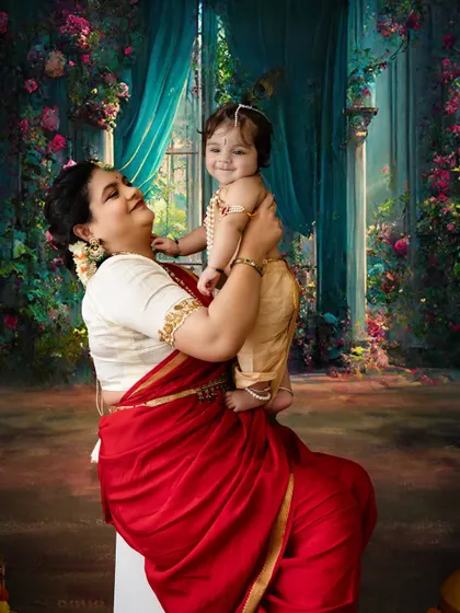 The joy of a mother lifting her child is universal. This beautiful moment is captured during a special Janmashtami session.